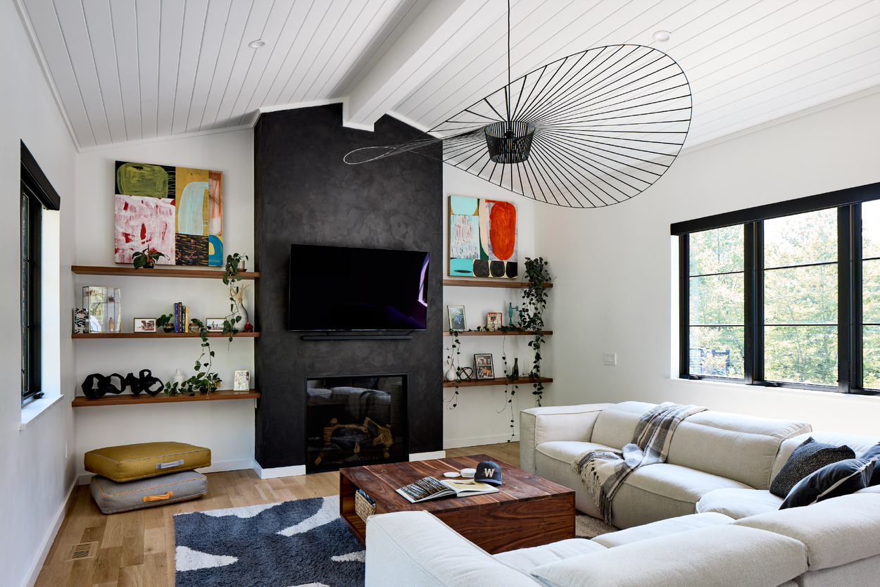 Vaulted shiplap living room with dark plaster fireplace and floating shelves in a McLean, VA home renovation by Four Brothers Design + Build Vaulted shiplap living room with dark plaster fireplace and floating shelves in a McLean, VA home renovation by Four Brothers Design + Build