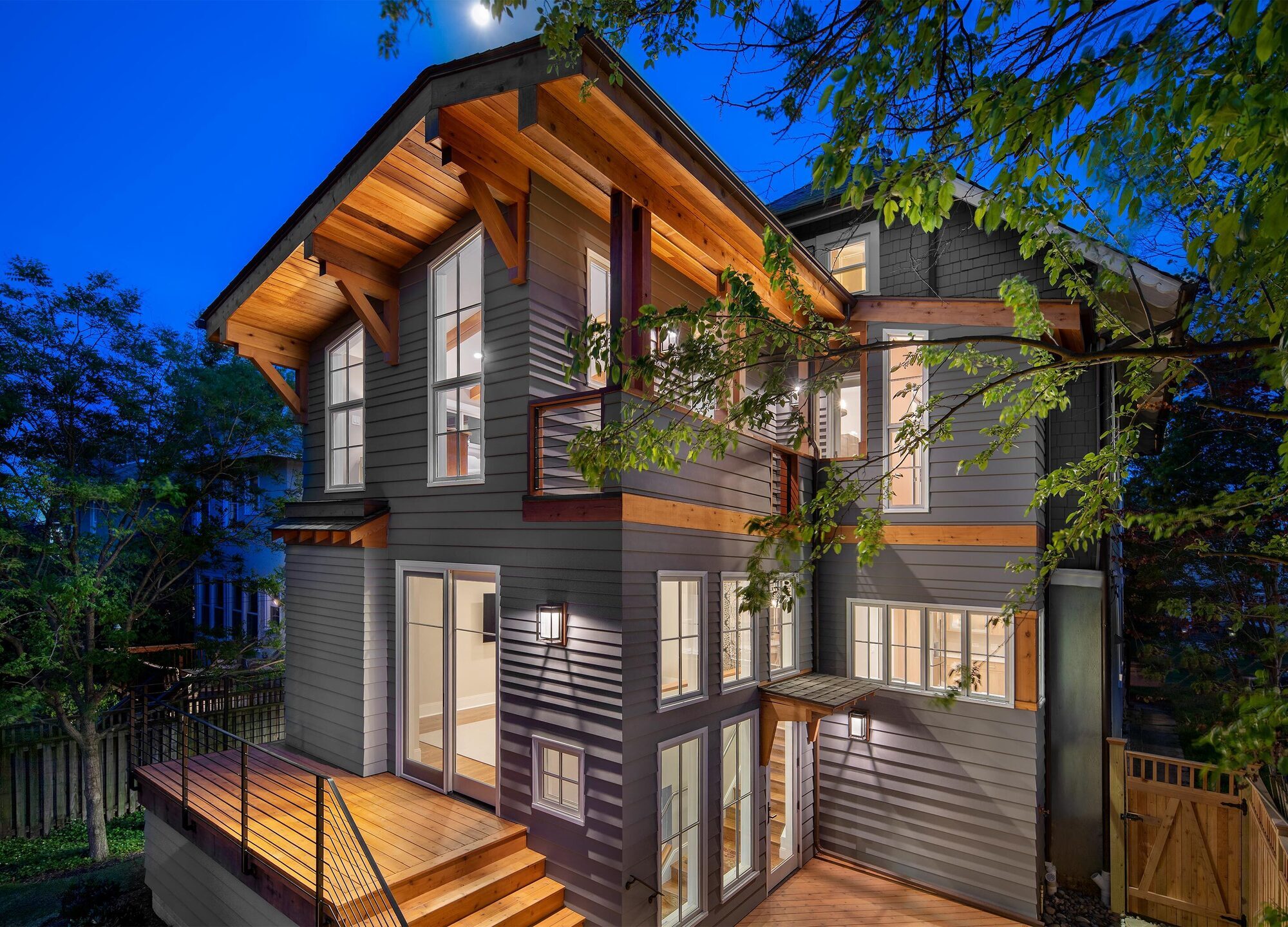 Exterior home renovation with custom lit deck and gray siding